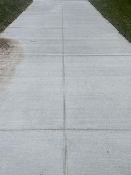 Concrete sidewalk with grass on both sides.