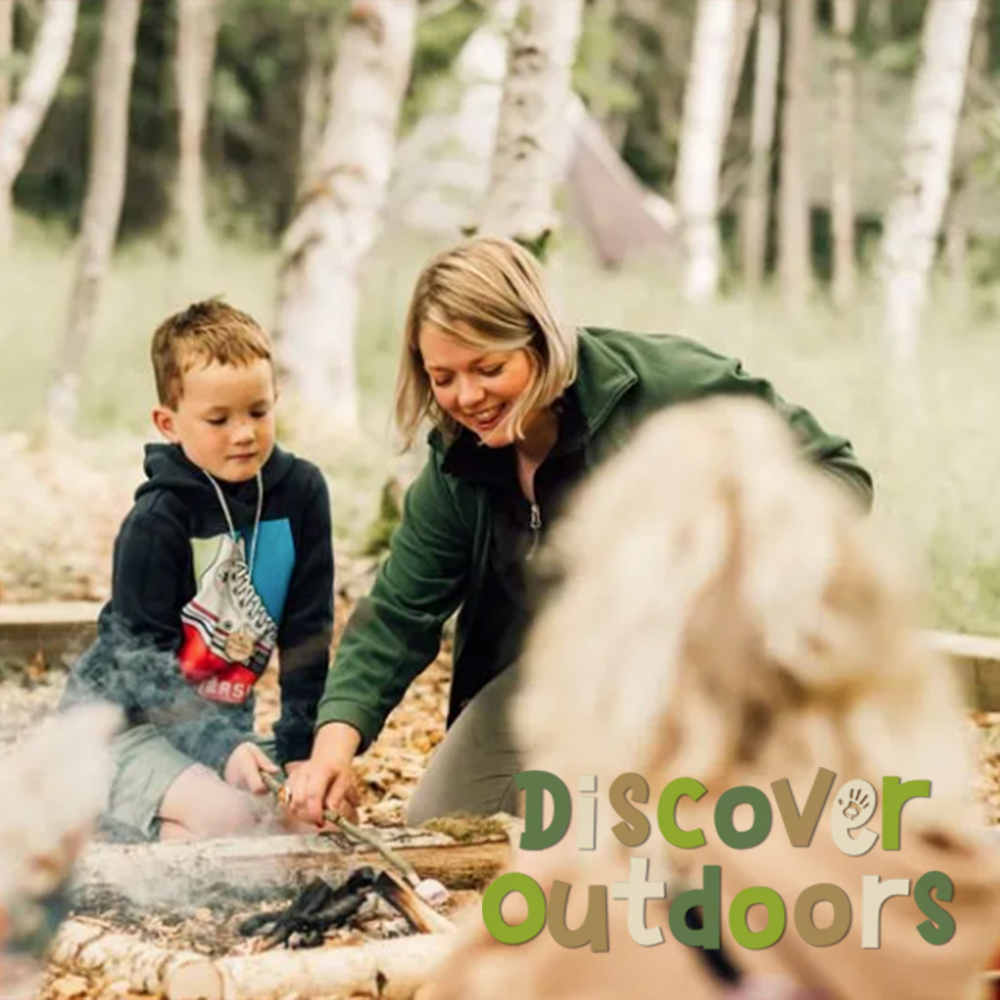 A woman and child are sitting around a campfire with discover outdoors written on the bottom