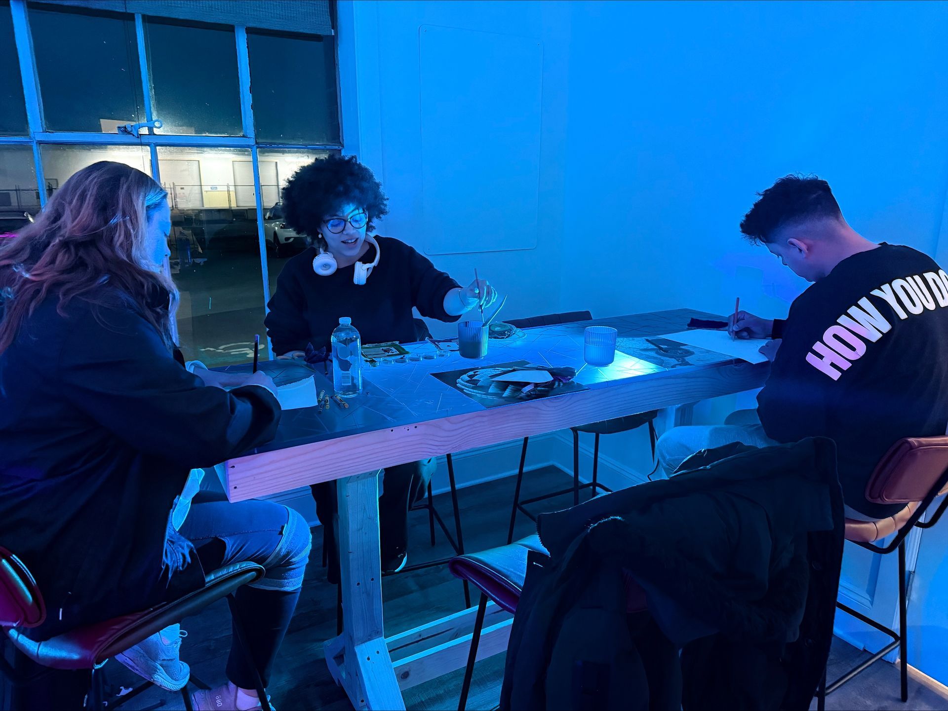 3 people making art at a table