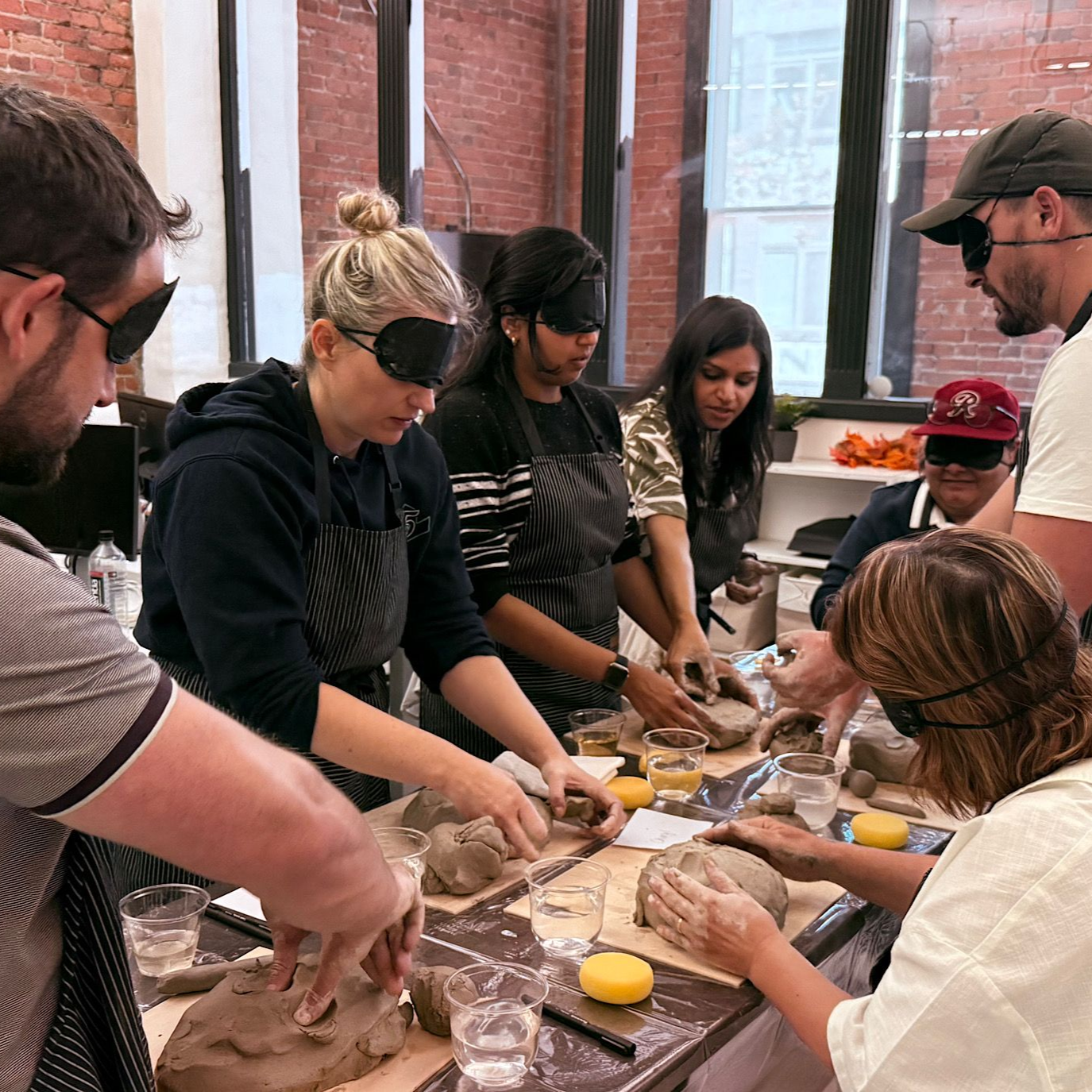4 people sculpting with blindfolds on