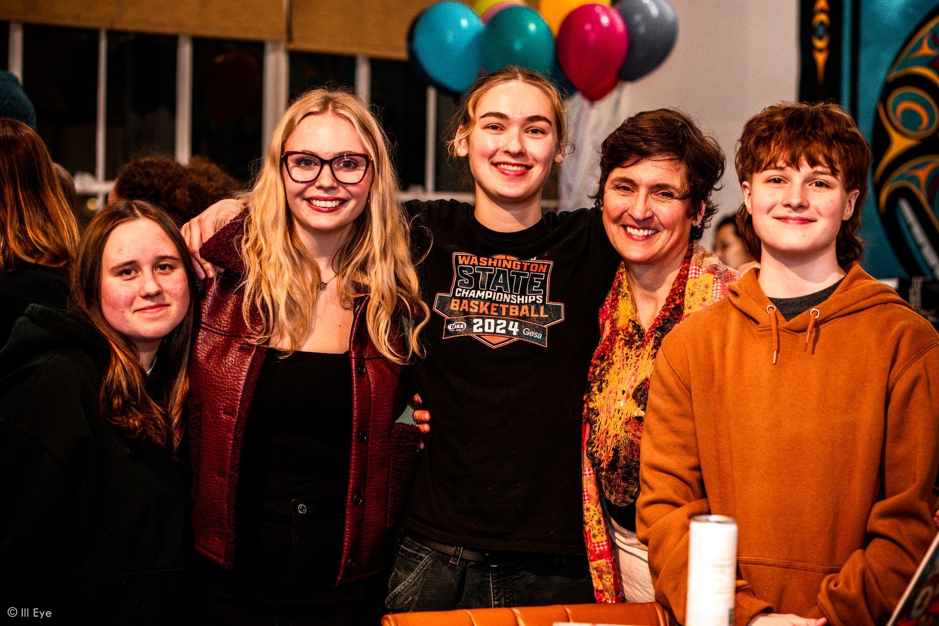 a family happy and smiling with balloons behind them