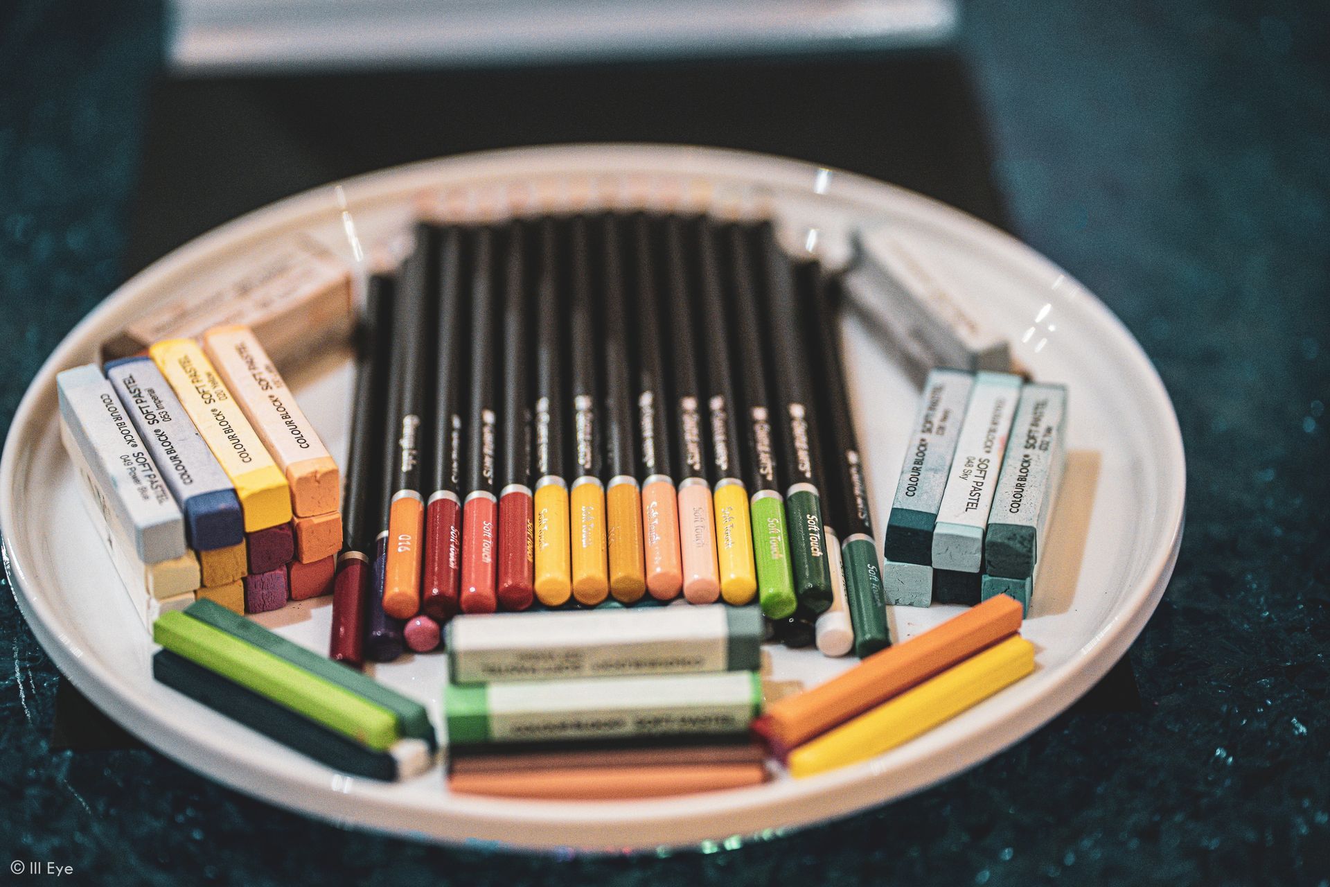 art pencils ond pastels on a white plate