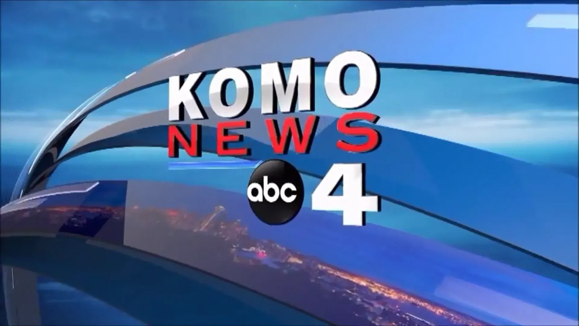 A logo for komo news abc 4 with a city in the background