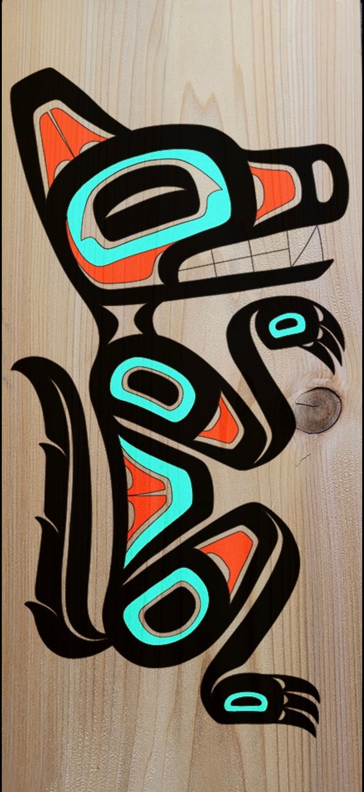 a turquoise, red and black formline wolf