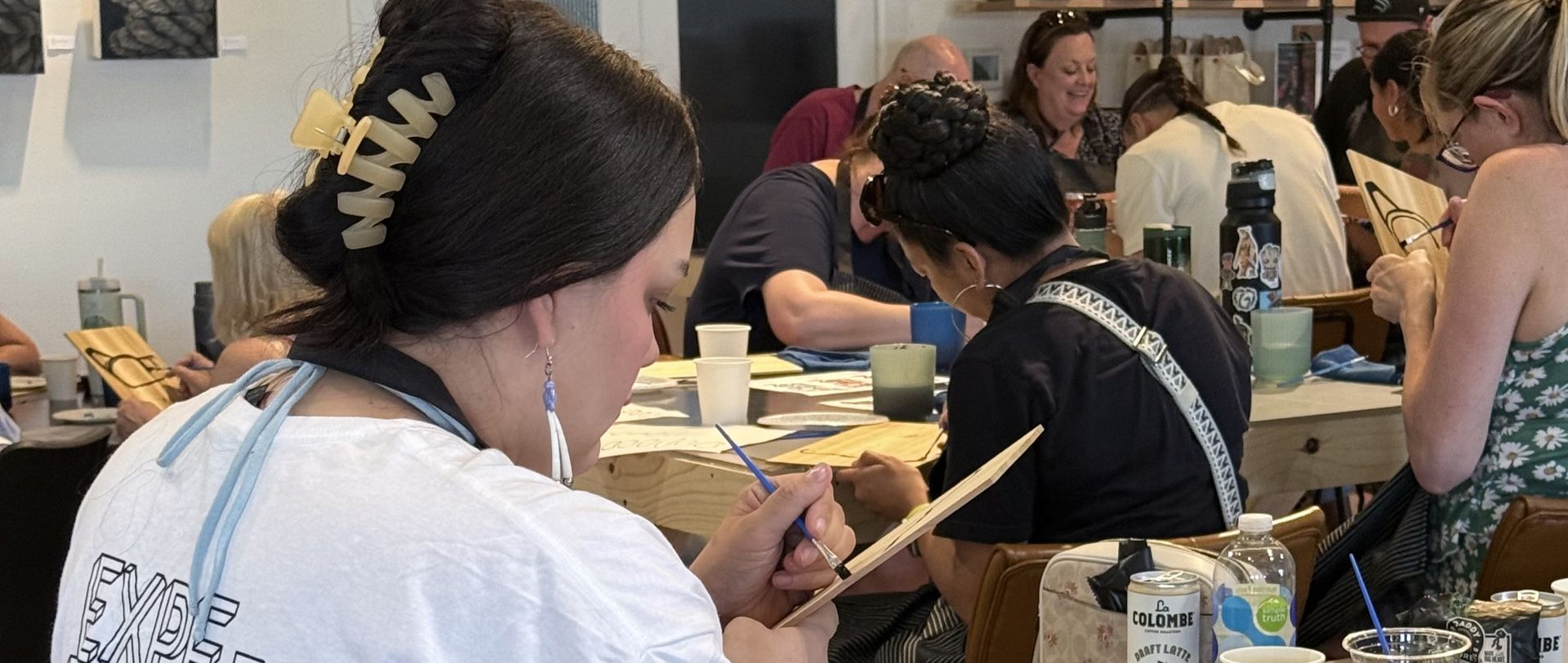 Woman painting on a cedar panel
