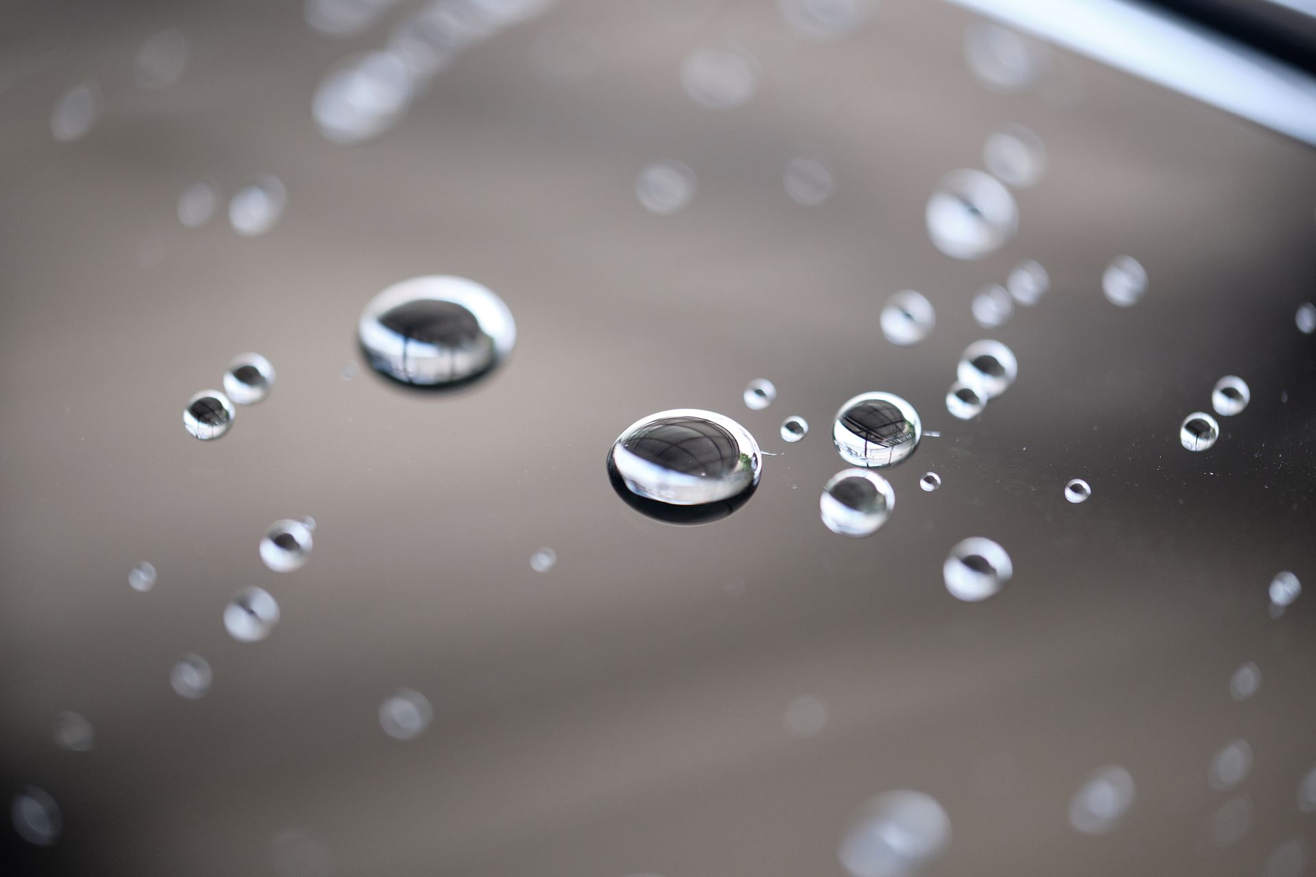 A close up of water drops on a glass surface.