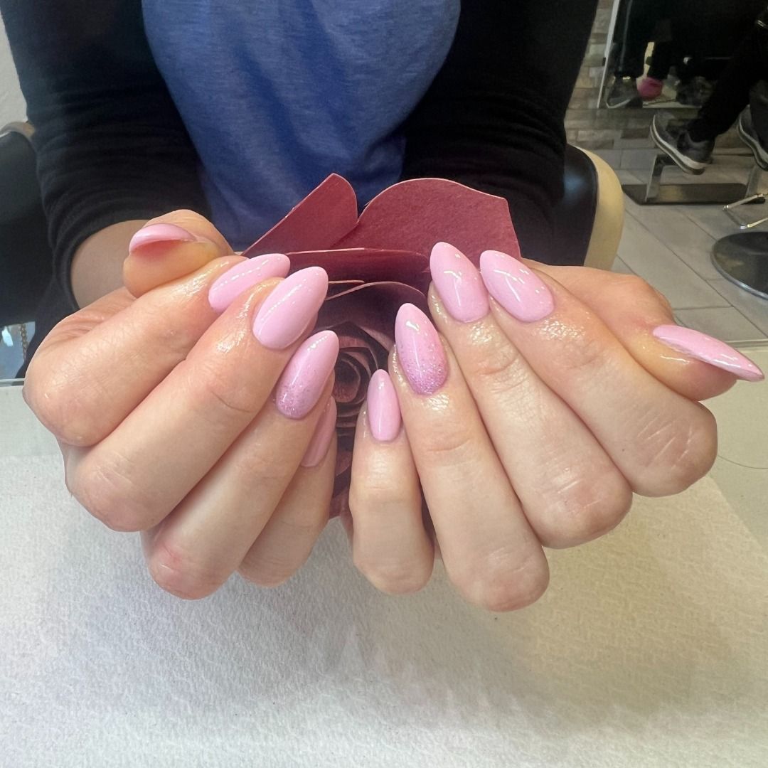 Una donna con le unghie rosa tiene una rosa tra le mani