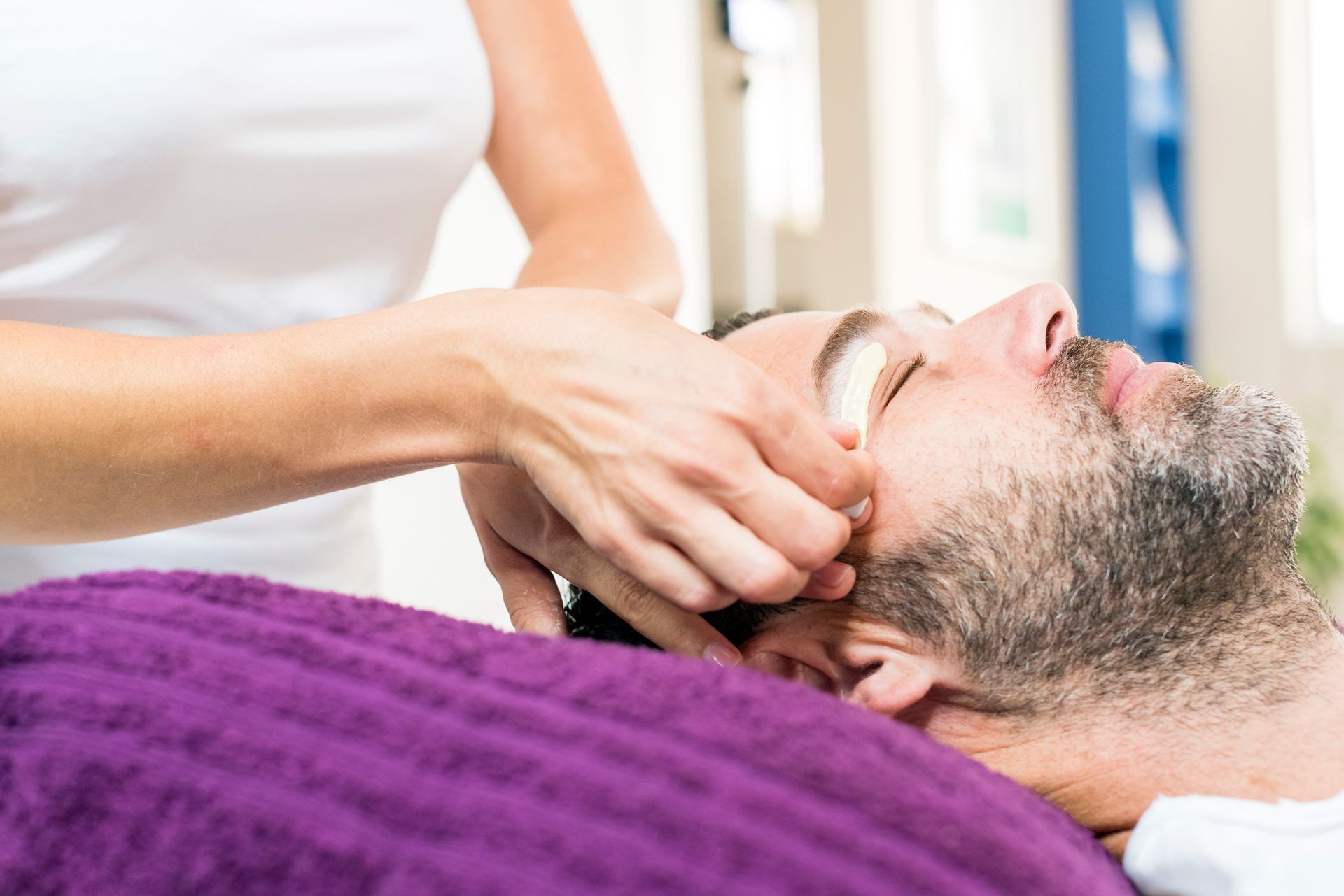 Un uomo si sta sottoponendo a un trattamento viso in una spa.