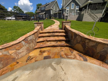Stone pathway with steps leading to houses on a sunny day.