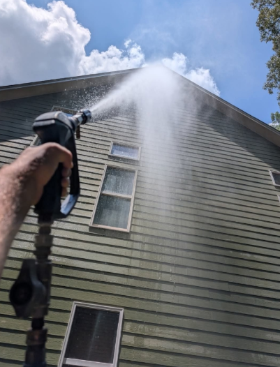 Deck with red double doors, window, awning, hot tub covered in black, and log cabin siding.