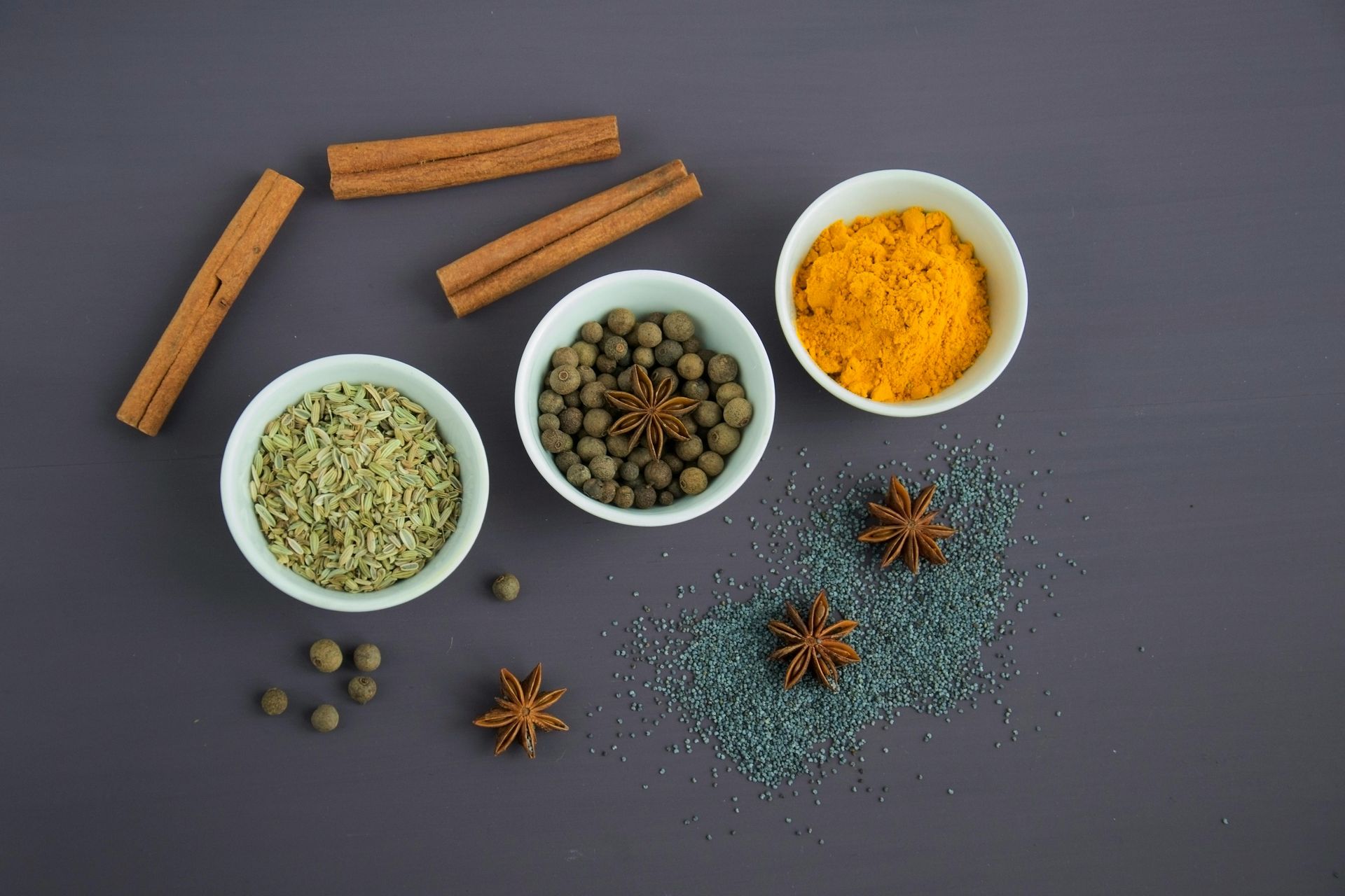 There are many different types of spices in bowls on the table.