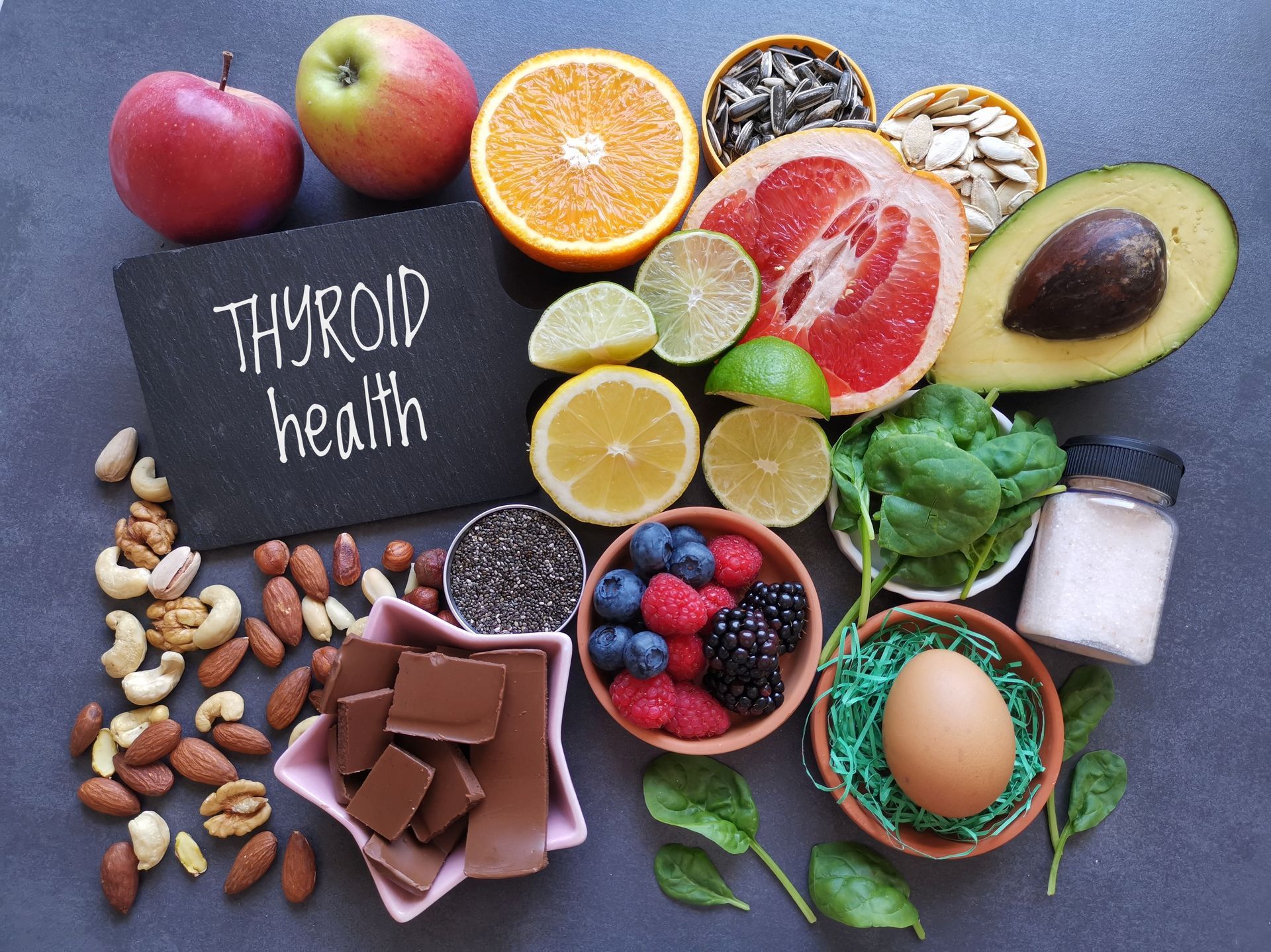 A table topped with a variety of fruits , vegetables , nuts and chocolate.