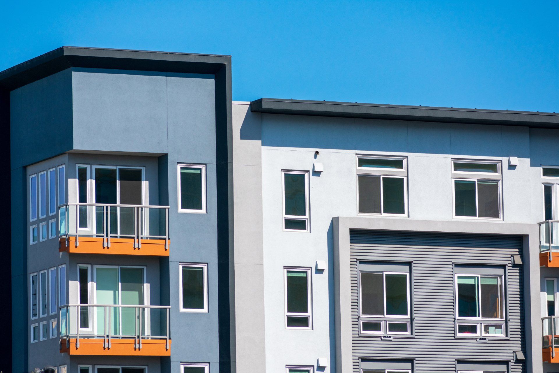 A row of apartment buildings with balconies on a sunny day.