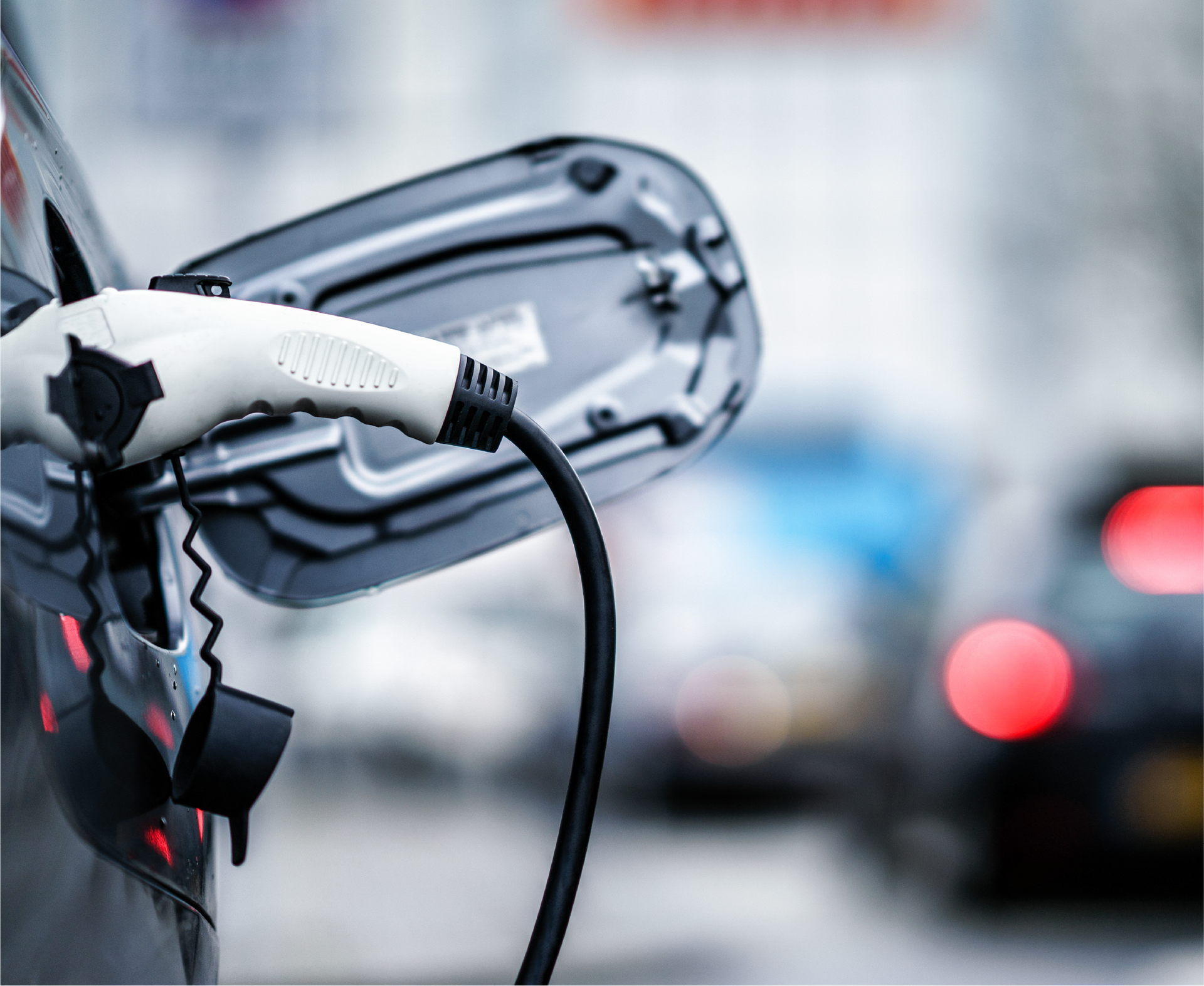 A close up of an electric car being charged on a city street.