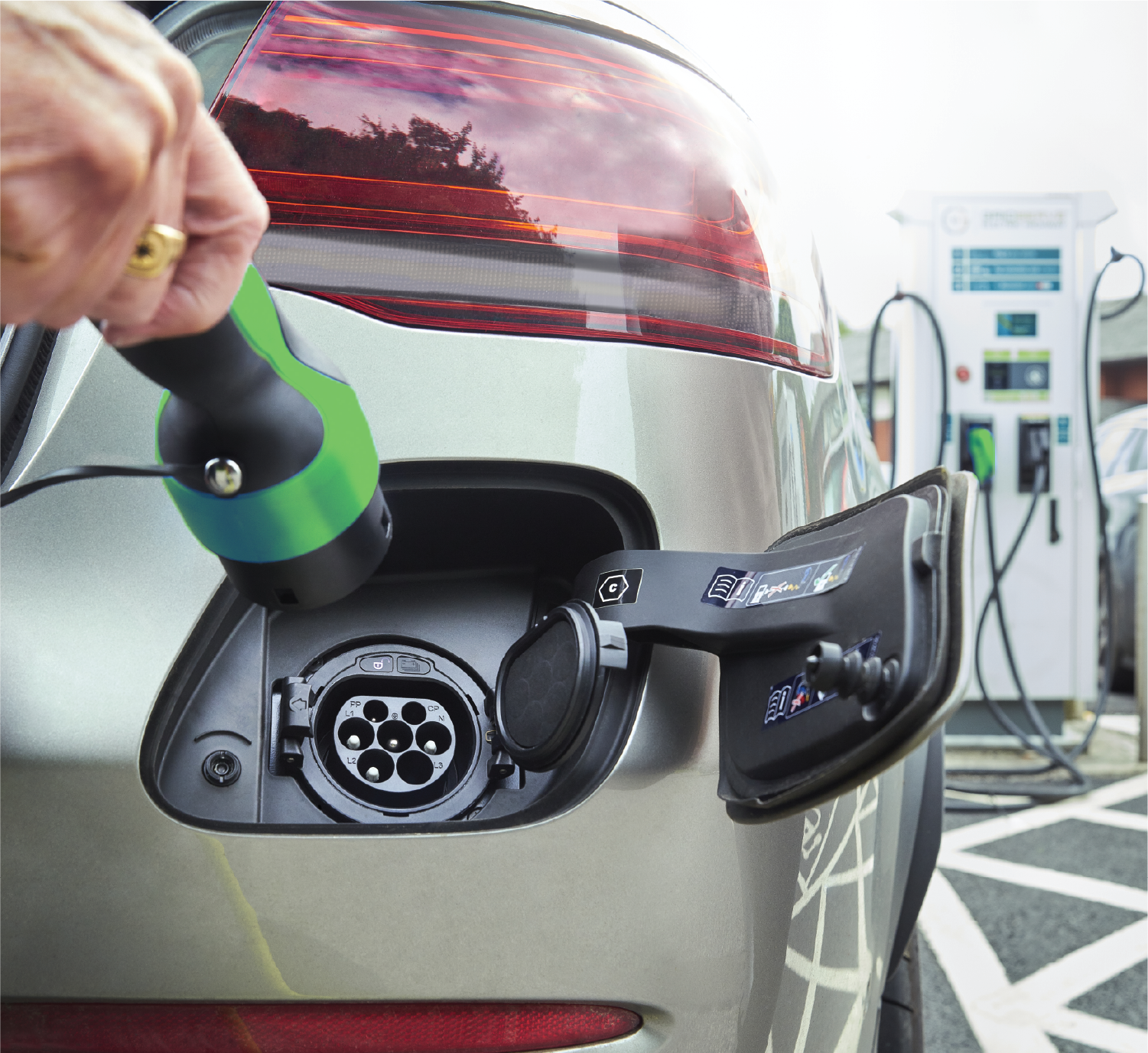 A person is charging an electric car at a charging station