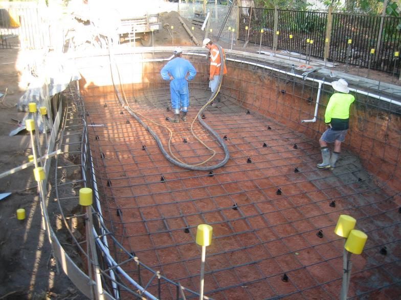 A Group of Construction Workers Are Working on a Swimming Pool — Rockscene Pools in Bentley Park, QLD