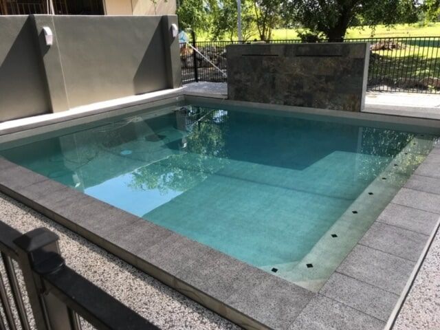 A Large Swimming Pool With a Fence Around It — Rockscene Pools in Bentley Park, QLD
