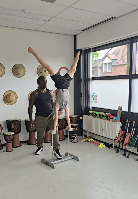 Een man en een jongen doen een handstand in een kamer.