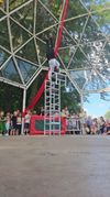 Een man doet een handstand op stoelen voor een publiek. Optreden