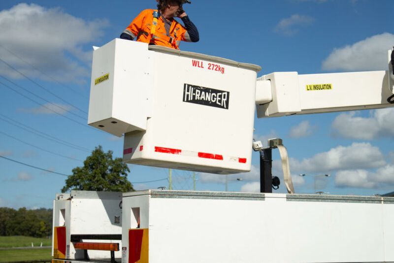 A man is sitting in a bucket on top of a ranger truck