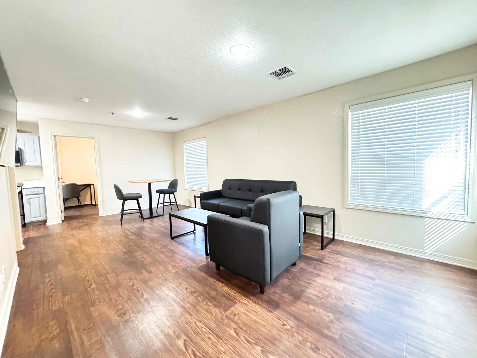 A living room with a couch , chairs , table and television.