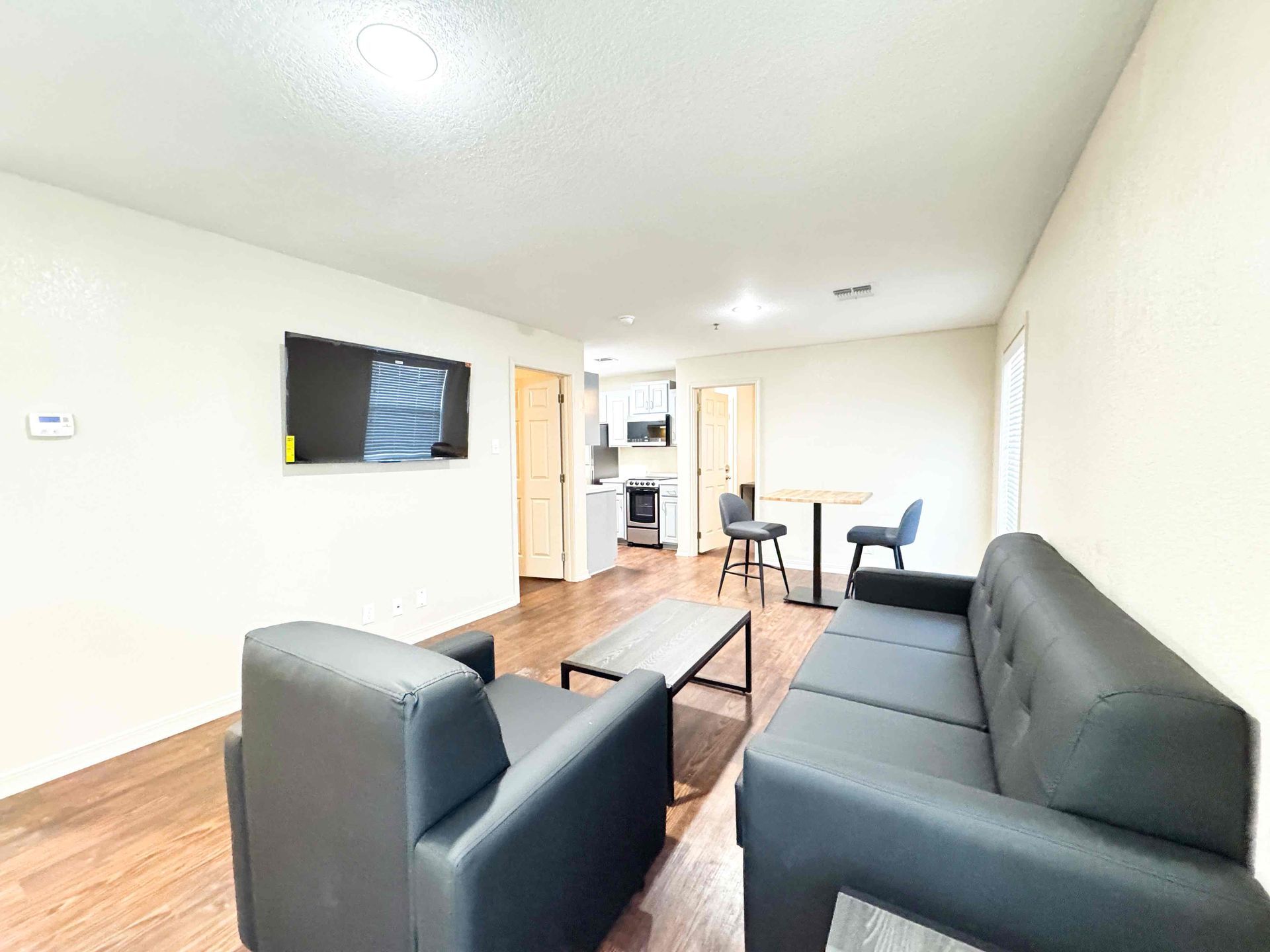 A living room with a couch , chairs , table and television.