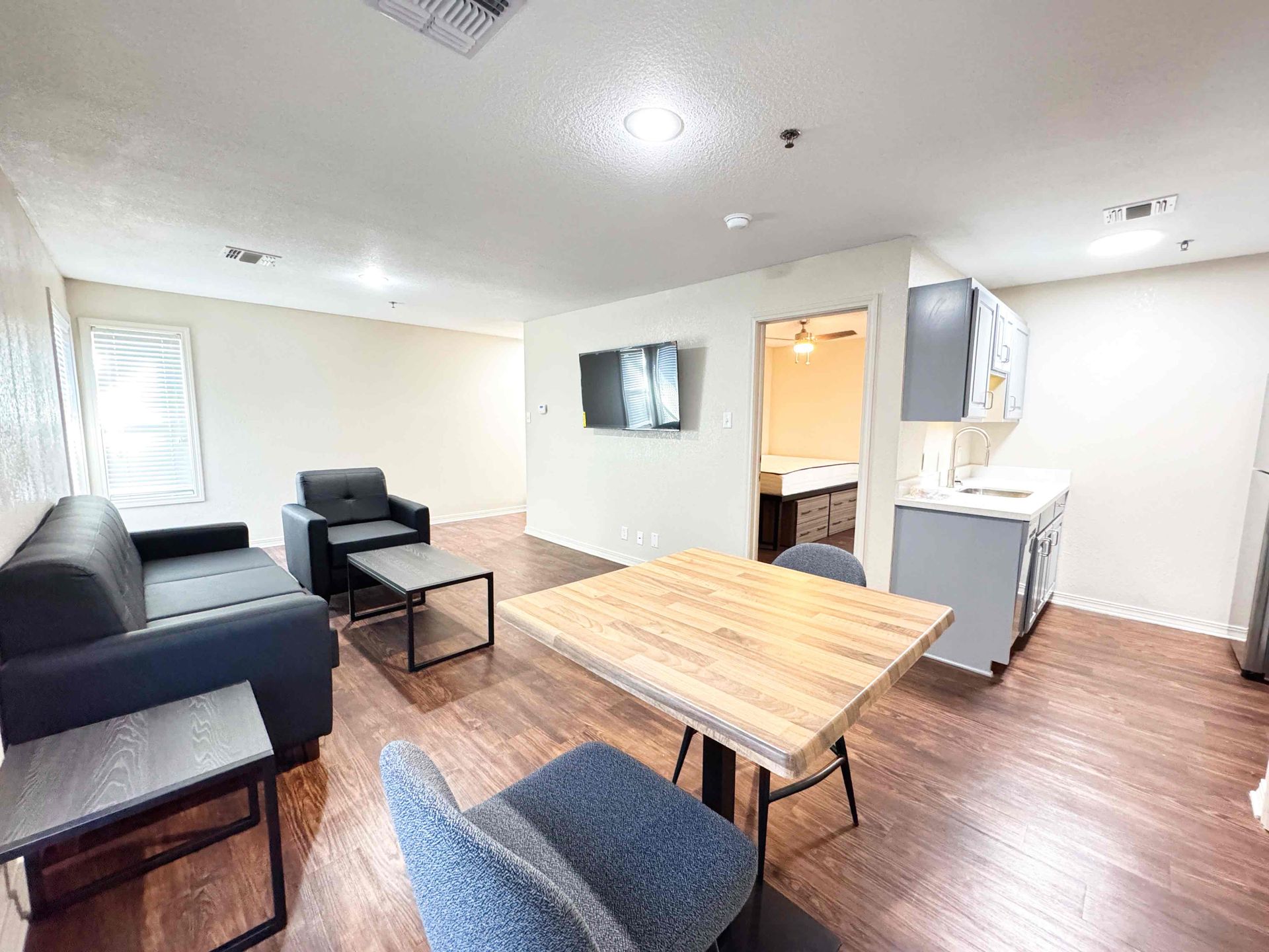 A living room with a couch , chair , coffee table and television.