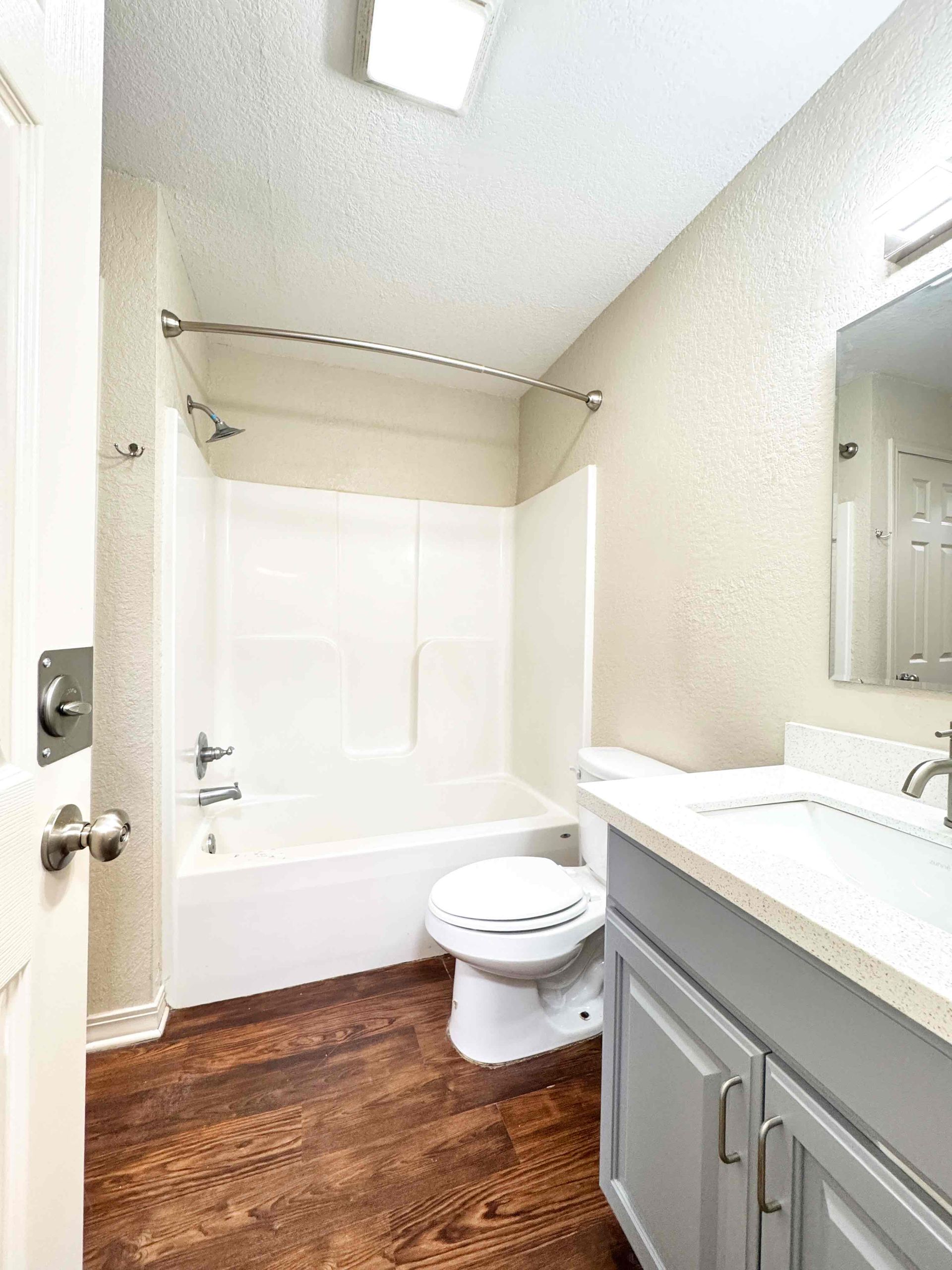 A bathroom with a sink , toilet , bathtub and mirror.