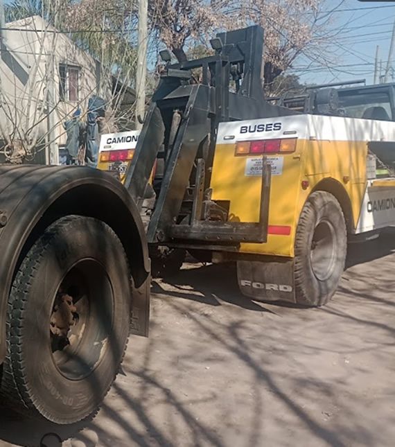 Una grúa Ford amarilla y blanca está estacionada al costado de la carretera.