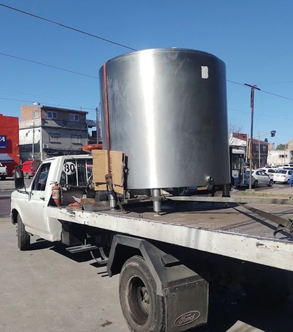Una camioneta Ford transporta un gran tanque de acero inoxidable.