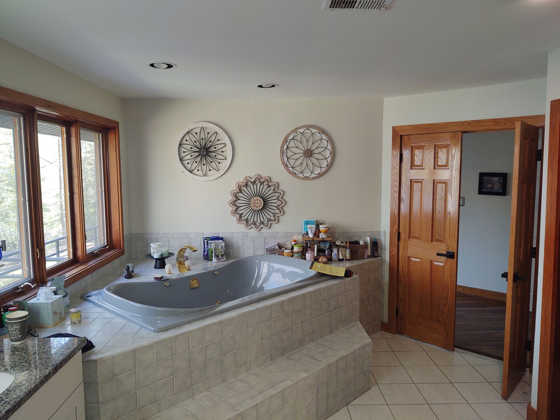 A bathroom with a built-in tub, decorative wall art, and a wooden door.
