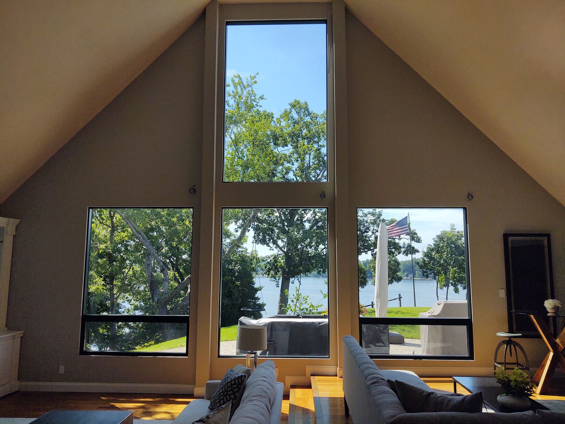 A living room with a lot of windows and a view of a lake