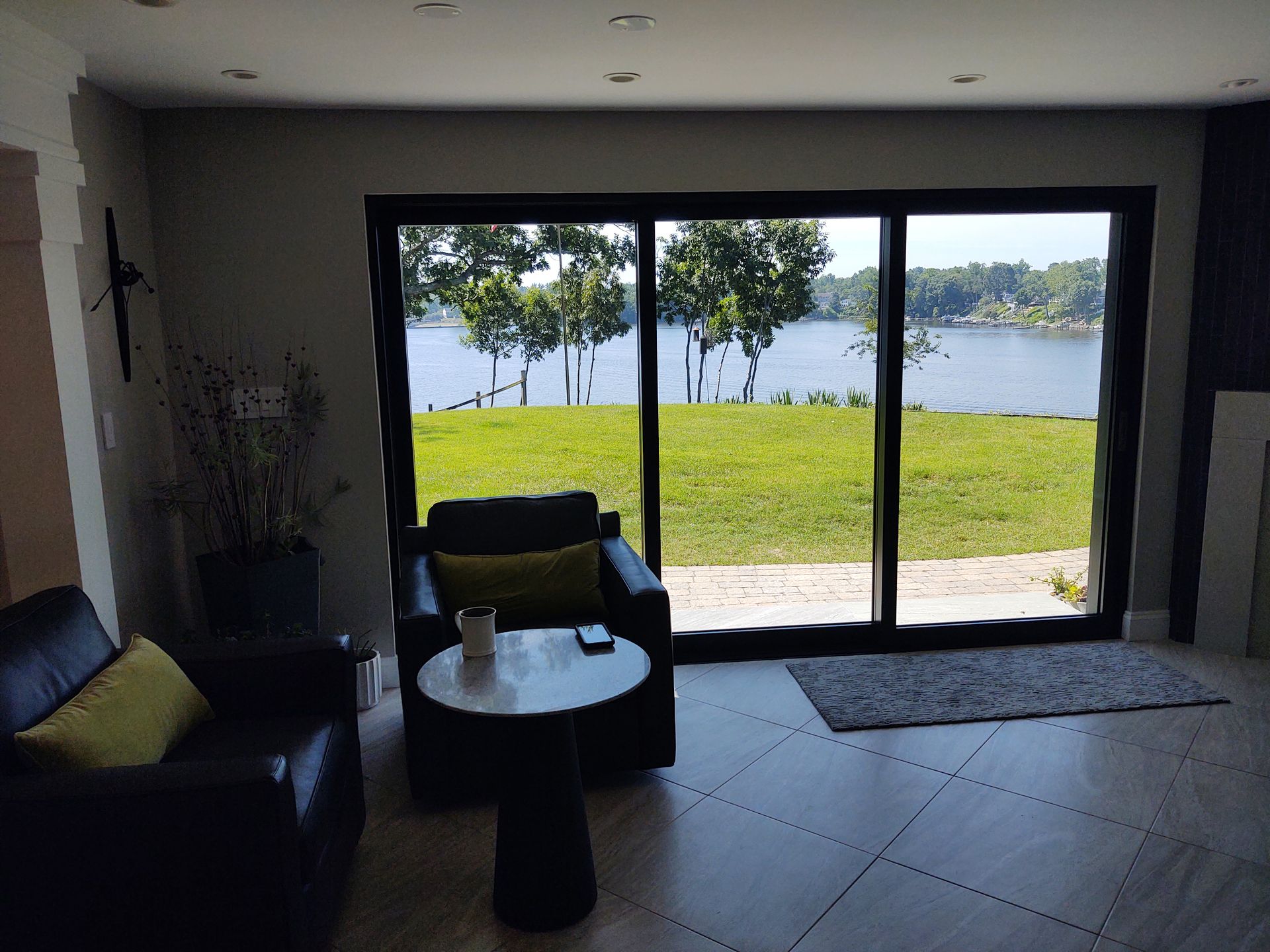 A living room with a view of a lake through a sliding glass door