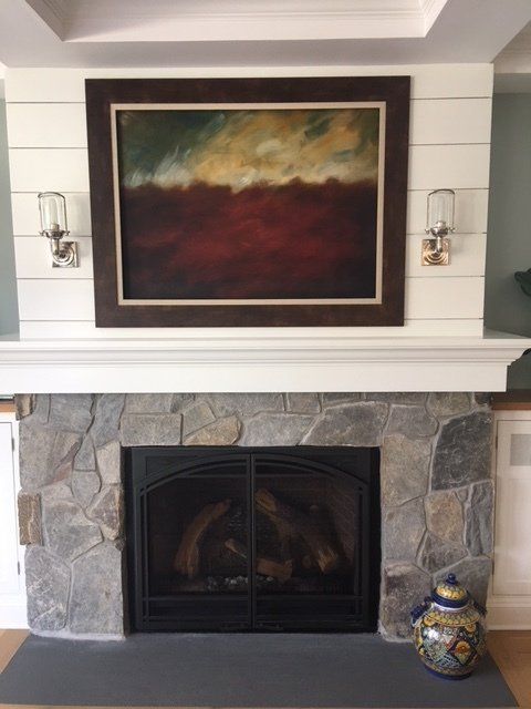 A fireplace with a painting on the mantle above it