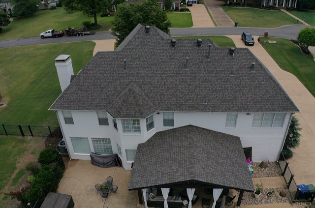 an aerial view of a large white house with a gray roof .