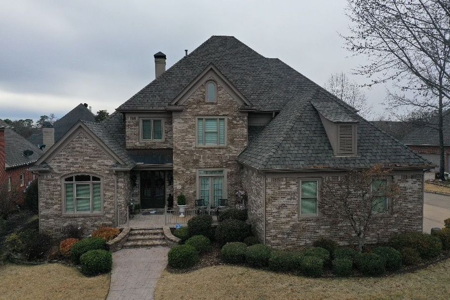 an aerial view of a large brick house with a gray roof .