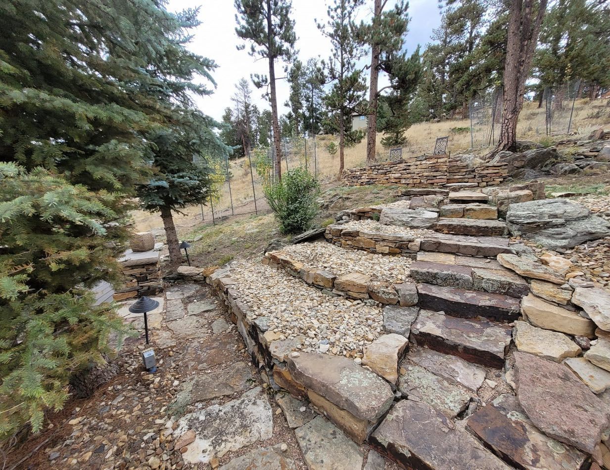 Stone steps and gravel path leading uphill in a wooded, mountainous setting.