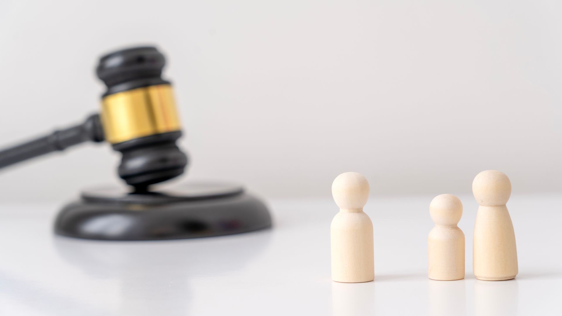 Guardianship Attorney with gavel and family figures representing legal guidance. Guardianship Attorney with gavel and family figures representing legal guidance.