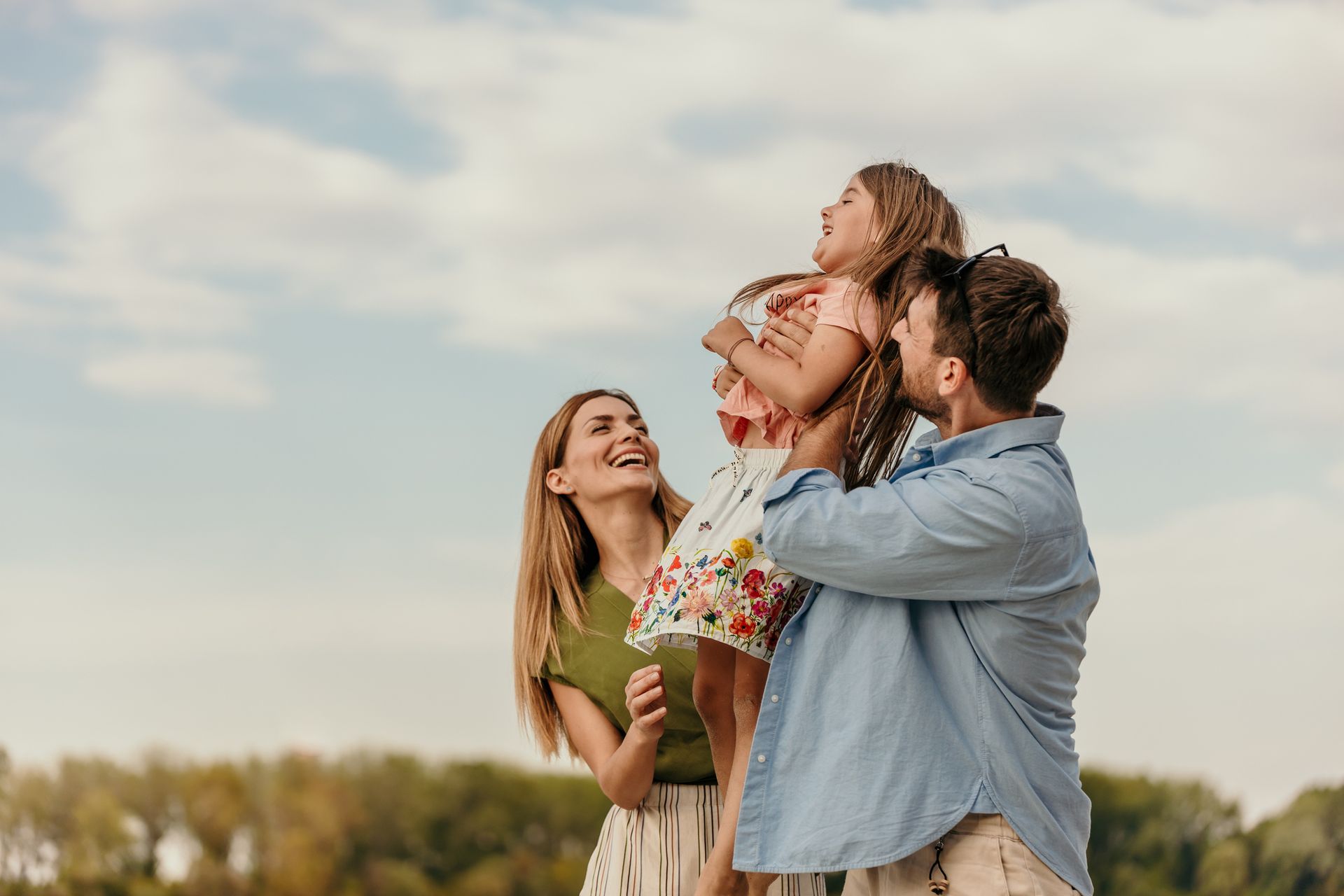 A family is standing next to each other in a field.