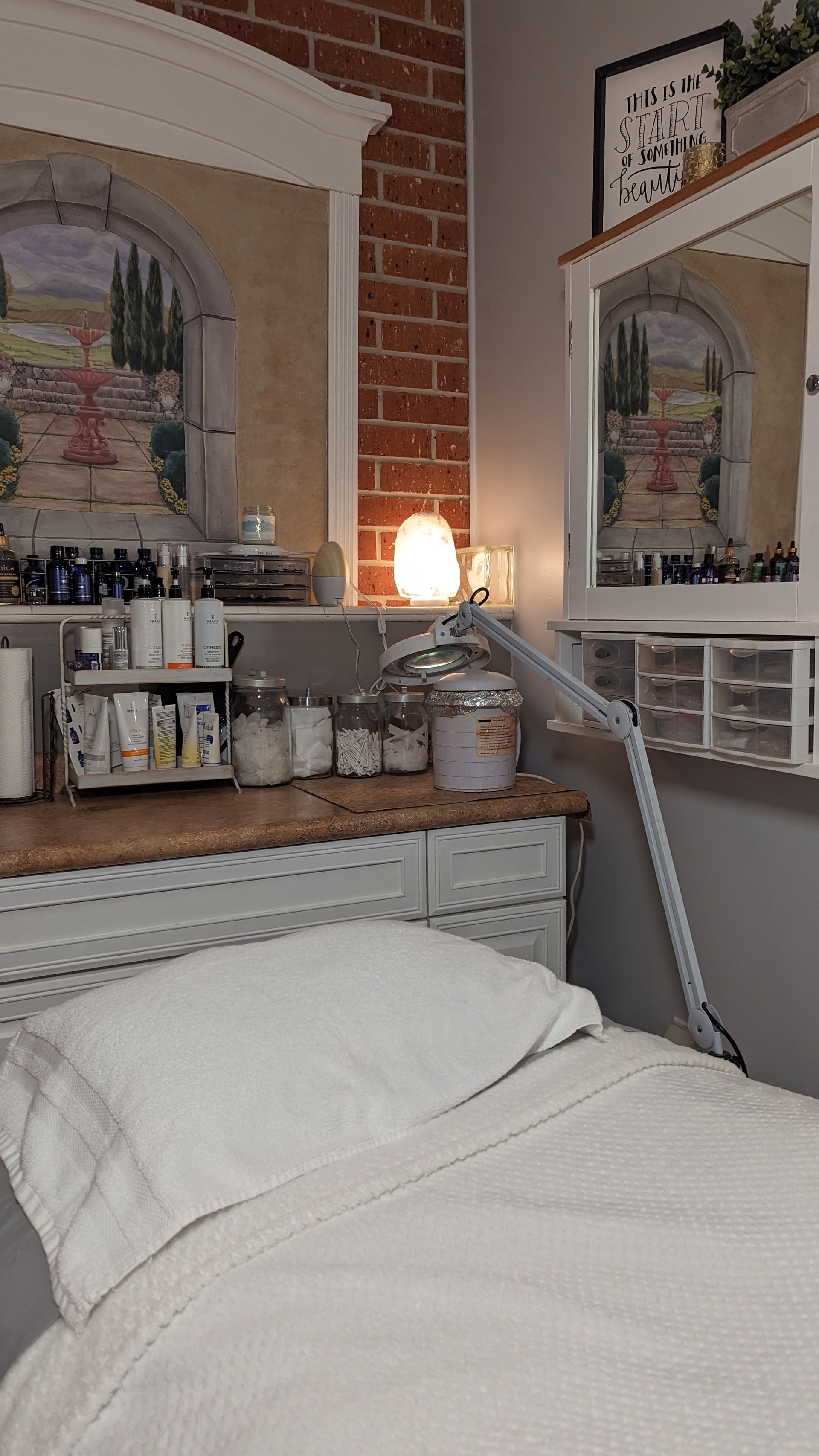 There is a bed in a room with a brick wall and a mirror.