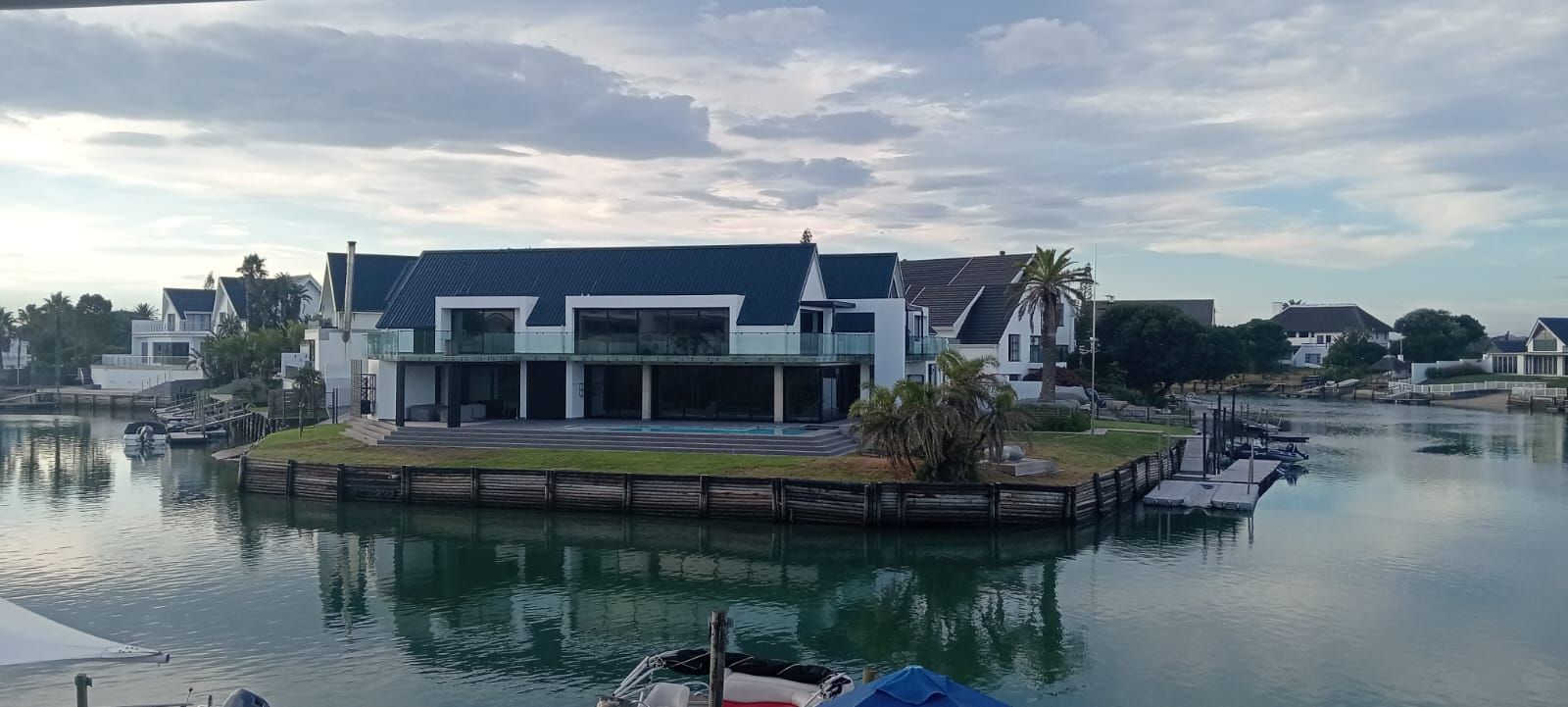 Houses on a waterway with cloudy sky.