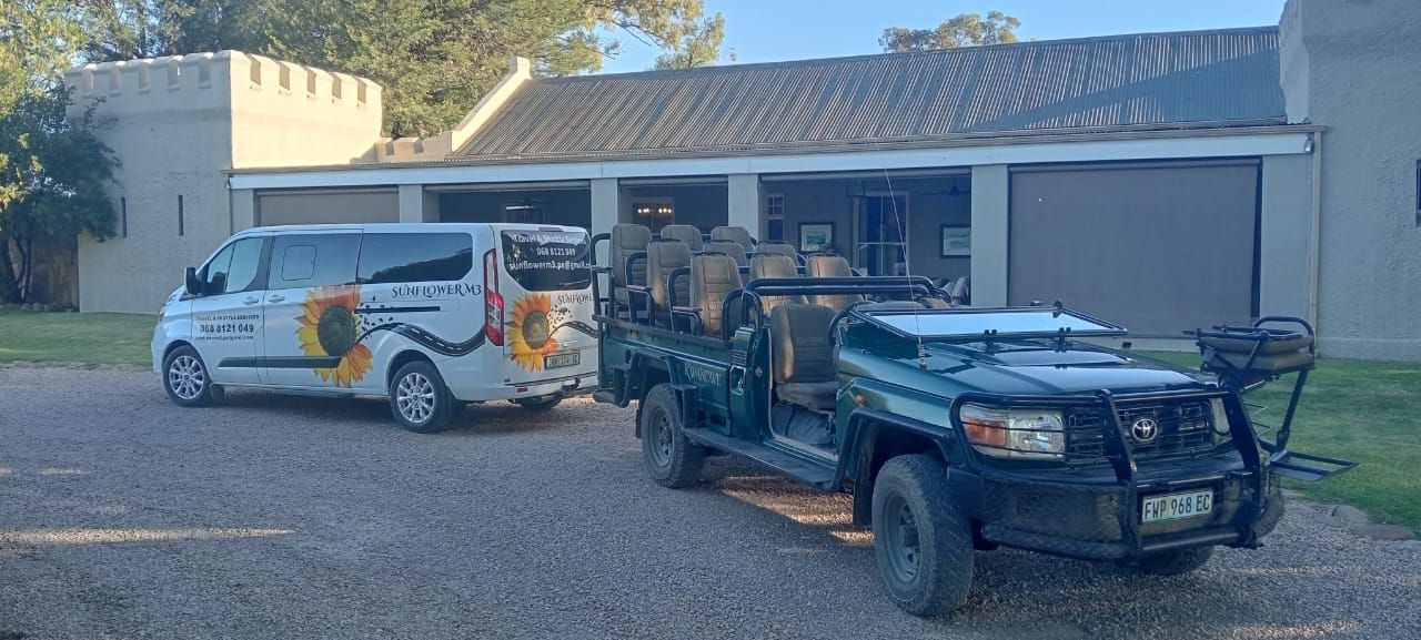 A van and a safari jeep parked in front of a building with a castle-like turret.