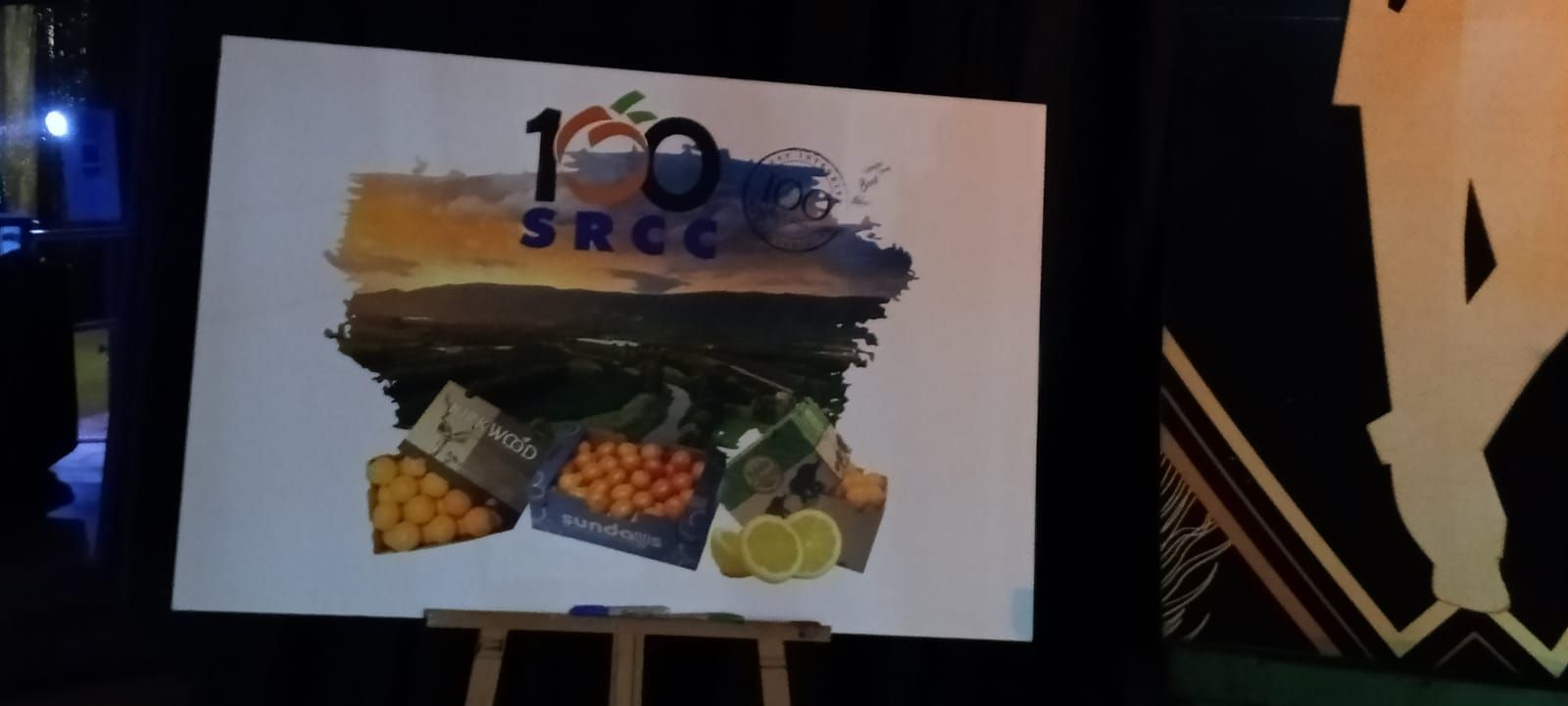 Sign on an easel: 100 SRCC logo with fruit illustrations.
