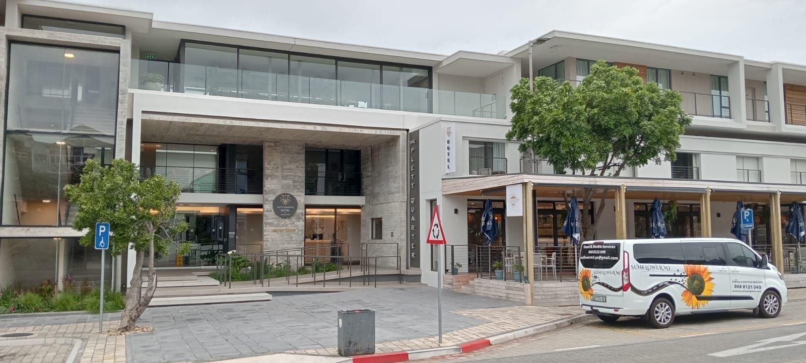 A modern building with a van parked in front.