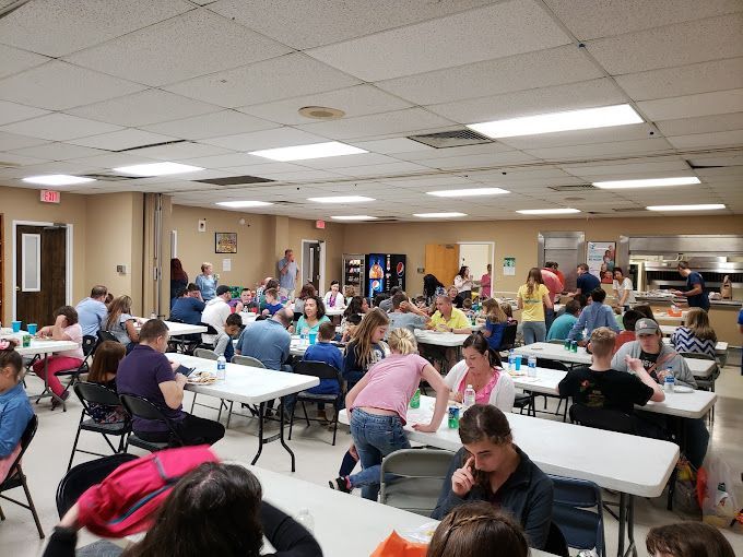 A large group of people are sitting at tables in a large room.