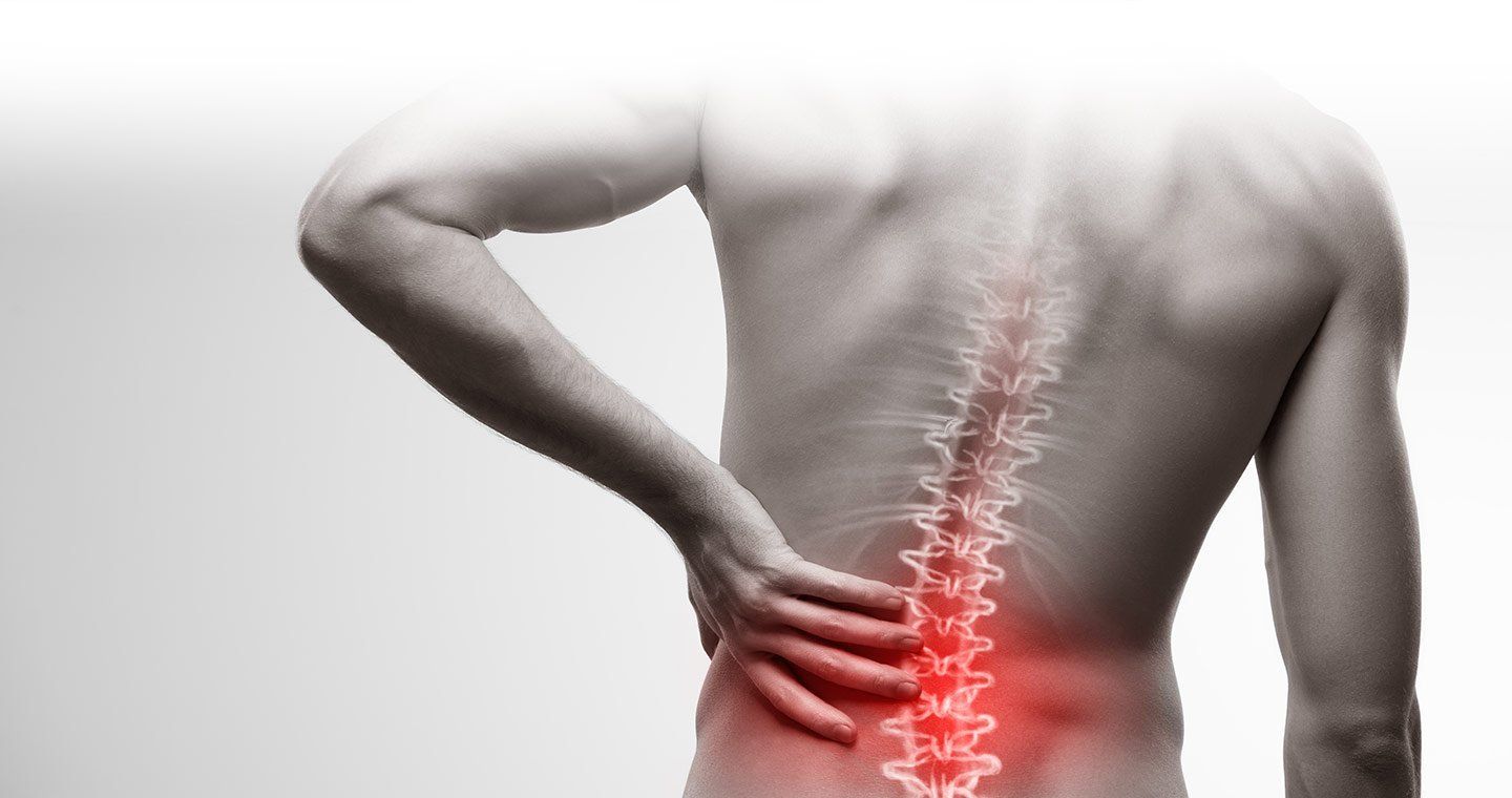 Man with back pain, hand on lower back, red highlight on spine.