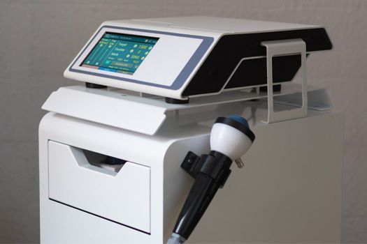 White medical device called stemwave for therapy with touchscreen display and handheld applicator.