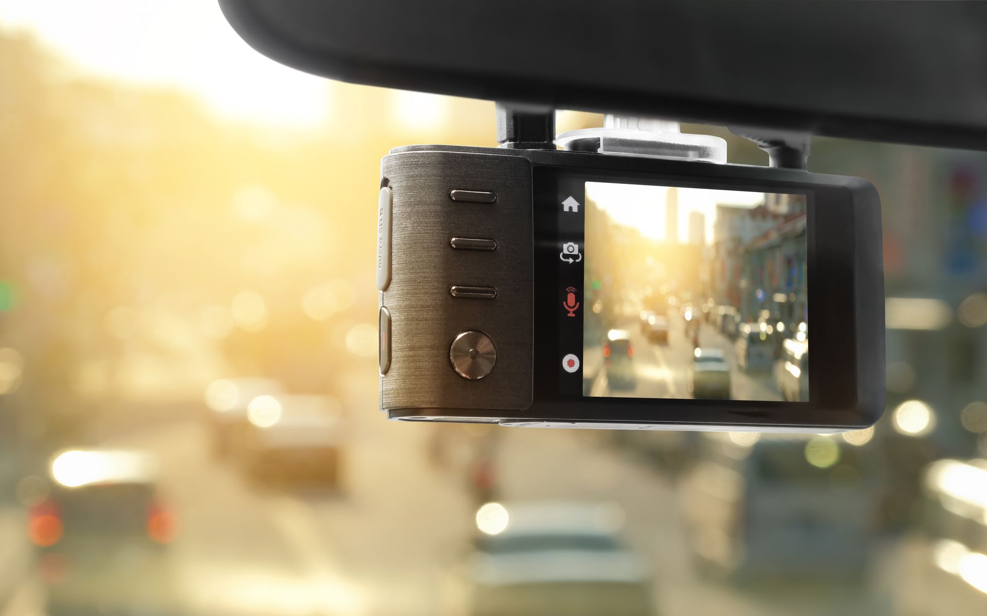 Dashcam mounted behind rearview mirror, filming street scene.