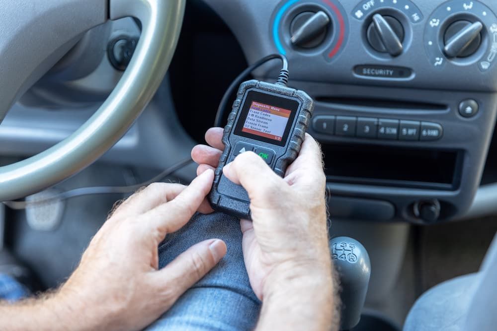 A Person is Holding a Device in Their Hand in a Car — Mt Isa Four Wheel Drive Services in Mount Isa City, QLD