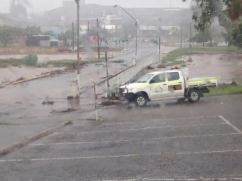 A Flooded Street With a White Utility Truck Parked Near a Bridge — Mt Isa Four Wheel Drive Services in Mount Isa City, QLD